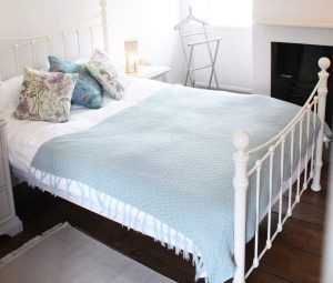 Bedroom 4 has a charming wrought iron bedstead with soft pastel linen