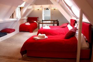 This attic bedroom is ideal for large family gatherings, with 4 single beds for children