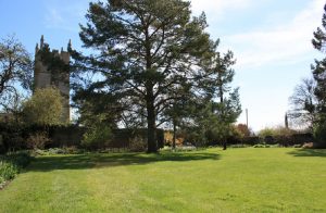 Beyond the large gardens of this big house, lies the local church.