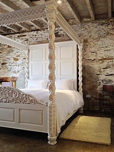 Ornate, carved, sumptuous 4 poster in the contemporary barn rooms at Devon Farmhouse, part of the The Big House Company