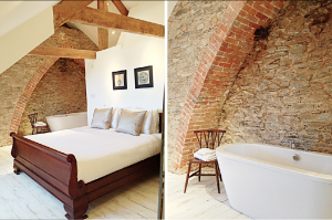 Beams and exposed brickwork create a sophisticated design in this bedroom at Devon Farmhouse