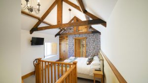 Exposed beams give this bedroom a cosy atmosphere at Tatham House in Somerset