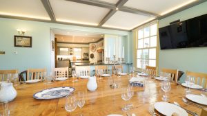 This party house in Somerset has a dining area with mood lighting and a large oak table