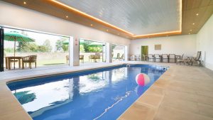 The indoor pool has bi-fold doors opening onto the walled garden and terrace area