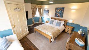 Shades of blue blend well in this bedroom with kingsize bed and sofa bed