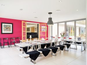 The trendy dining area with bi-fold doors which blend indoor/outdoor living on a summer day