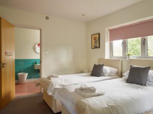 A calm and peaceful decor in Bedroom 2 with twin beds and ensuite bathroom